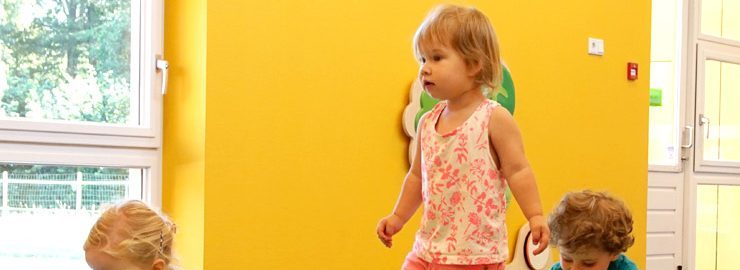 Kinderen bewegen in het gymlokaal met gele muren